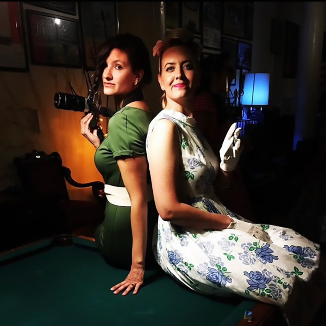 Two girls at a Shot In The Dark Mysteries murder mystery party game, solving The Adman Murder